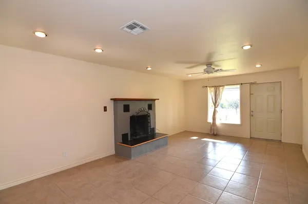 a view of an empty room with a fireplace and a window