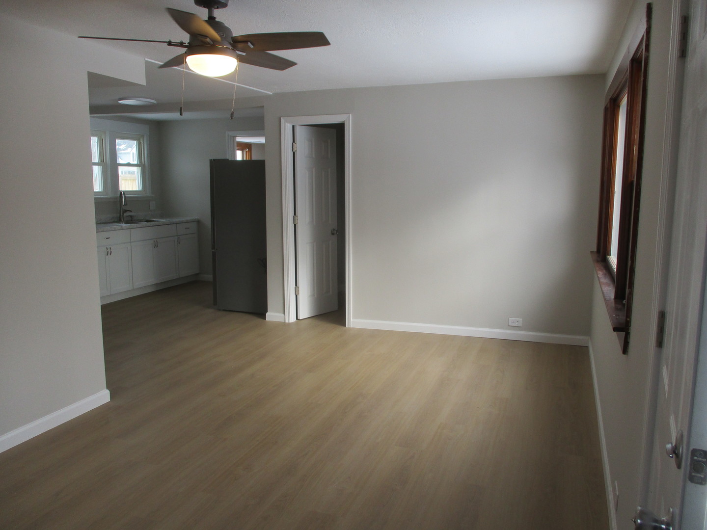 918 West Vine Street Champaign, IL 61821 - Photo 2 of 14 an empty room with wooden floor and a ceiling fan