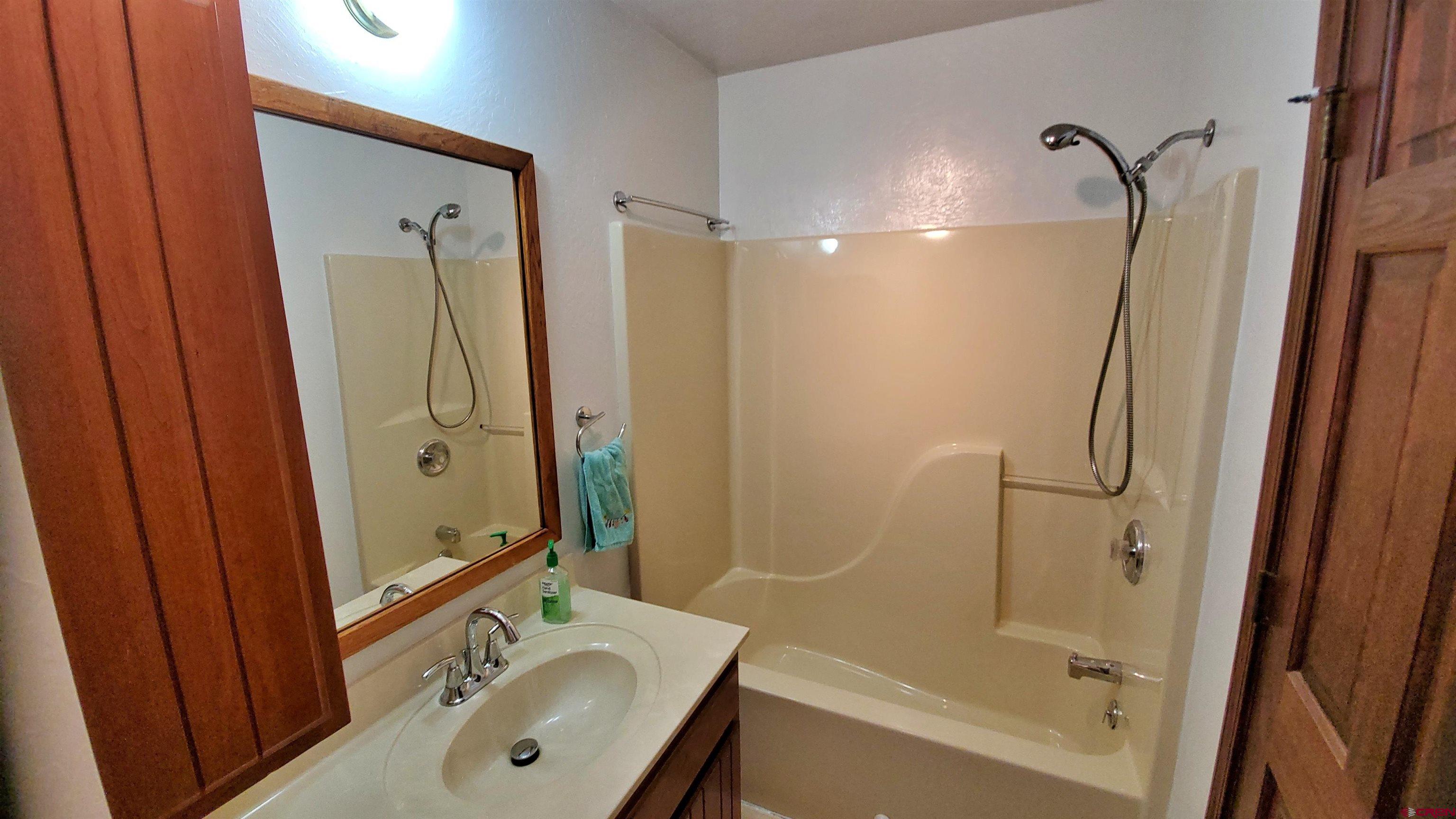 22250 County Rd M Cortez, CO 81321 - Photo 20 of 45 a bathroom with a tub shower sink vanity and a mirror
