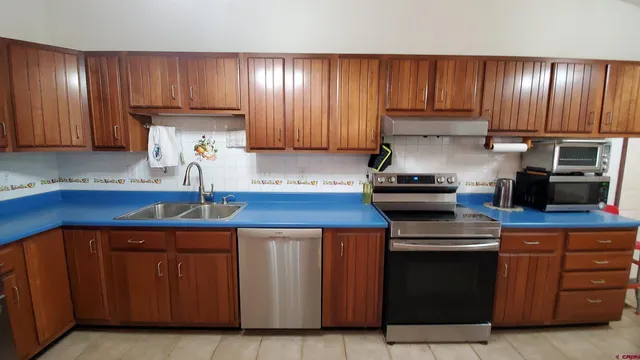 a kitchen with kitchen island granite countertop wooden cabinets and a stainless steel appliances