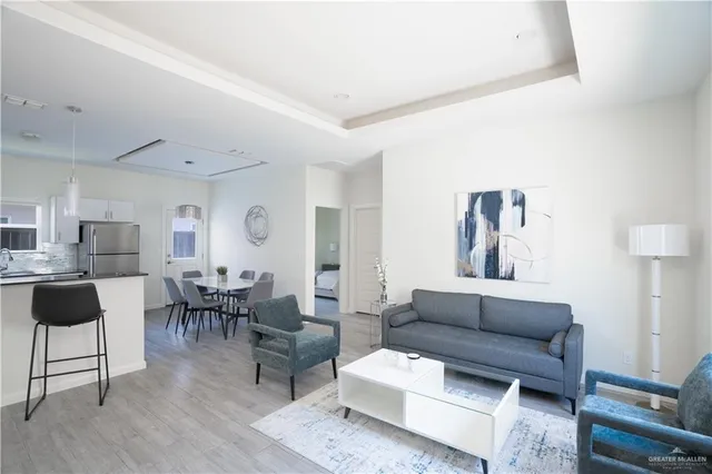 a living room with furniture and a dining table with wooden floor