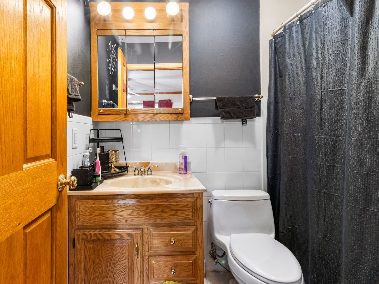215 Fernwood Road Montgomery, IL 60538 - Photo 11 of 28 a bathroom with a sink a toilet and a shower curtain