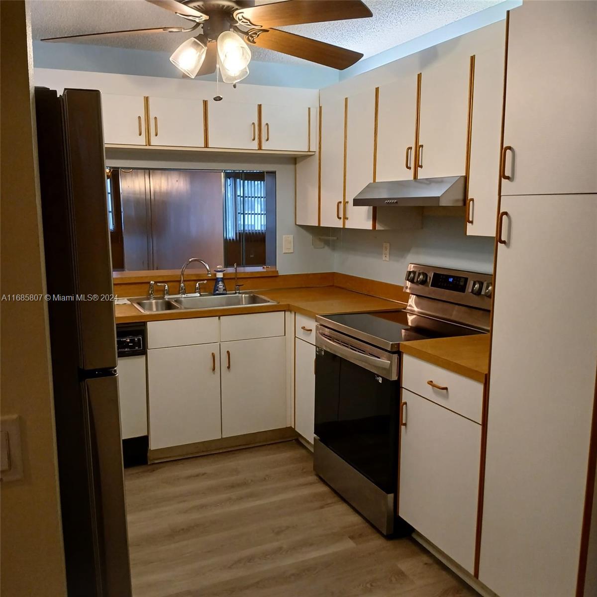 7136 South Devon Drive, Unit 207 Tamarac, FL 33321 - Photo 11 of 24 a kitchen with a sink stove and cabinets