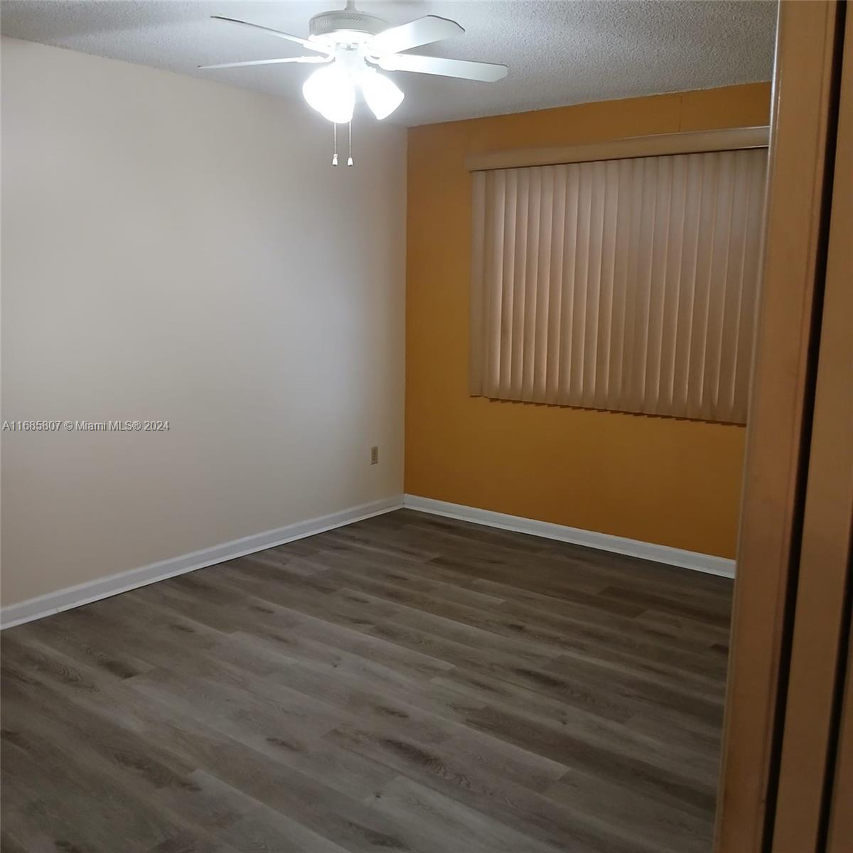 7136 South Devon Drive, Unit 207 Tamarac, FL 33321 - Photo 15 of 24 a view of an empty room with wooden floor and fan