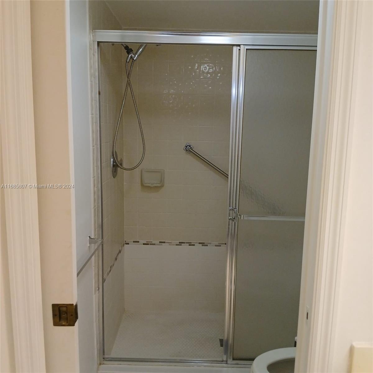7136 South Devon Drive, Unit 207 Tamarac, FL 33321 - Photo 16 of 24 a bathroom with a glass shower door