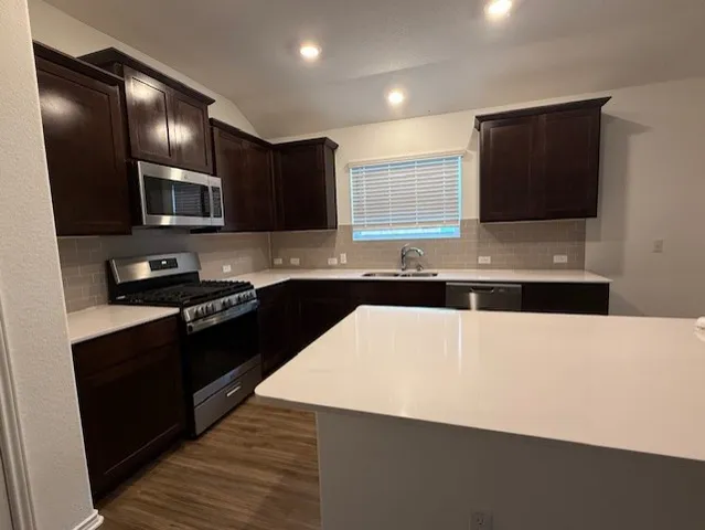 a kitchen with stainless steel appliances a microwave a sink and a stove