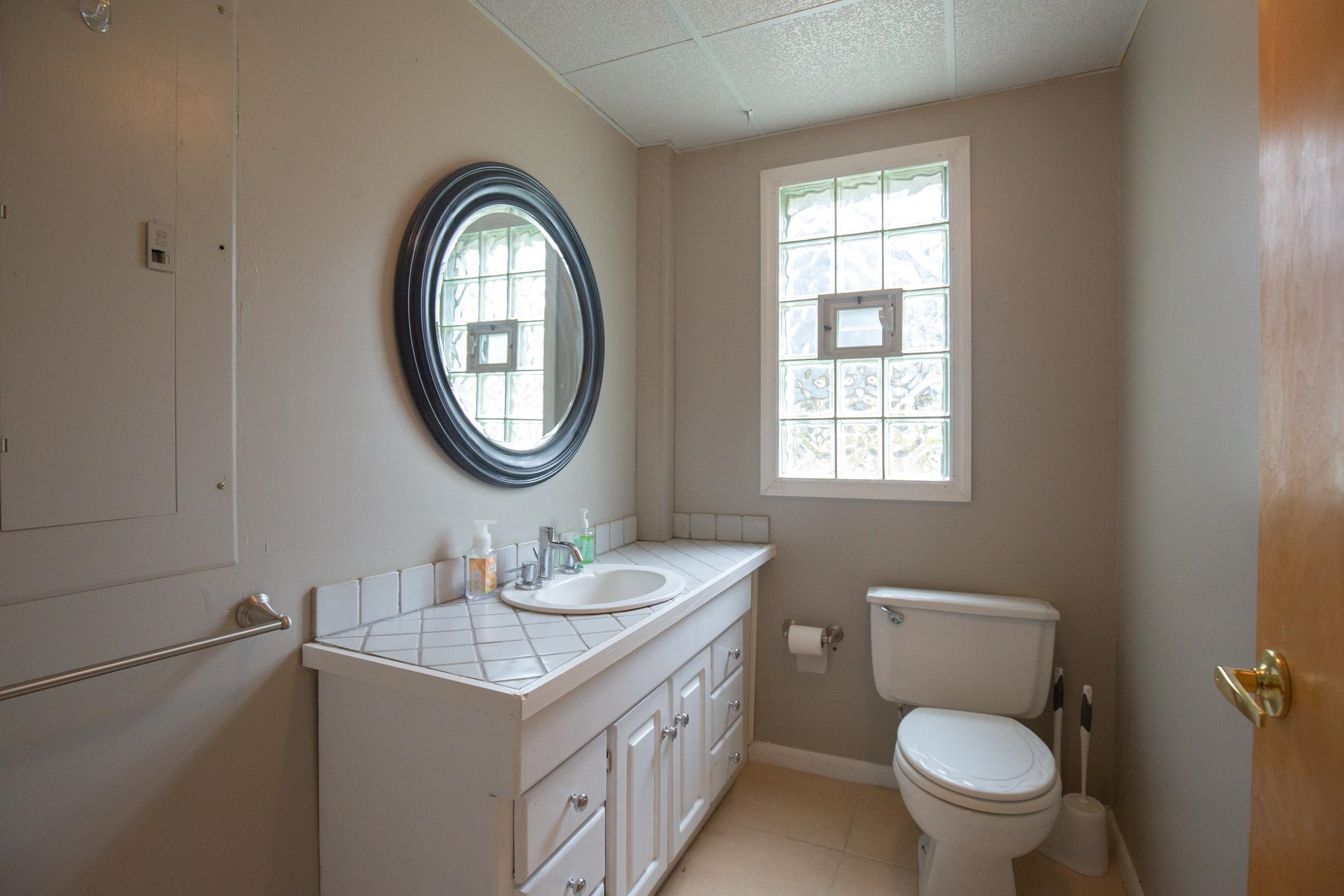 312 Ridge Cape May, NJ 08204 - Photo 15 of 32 a bathroom with a granite countertop toilet a sink and a mirror