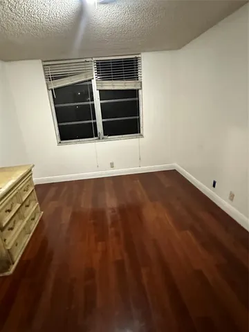 an empty room with wooden floor and closet