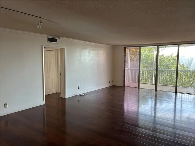 a view of kitchen with kitchen island a sink wooden floor and a dining table chair
