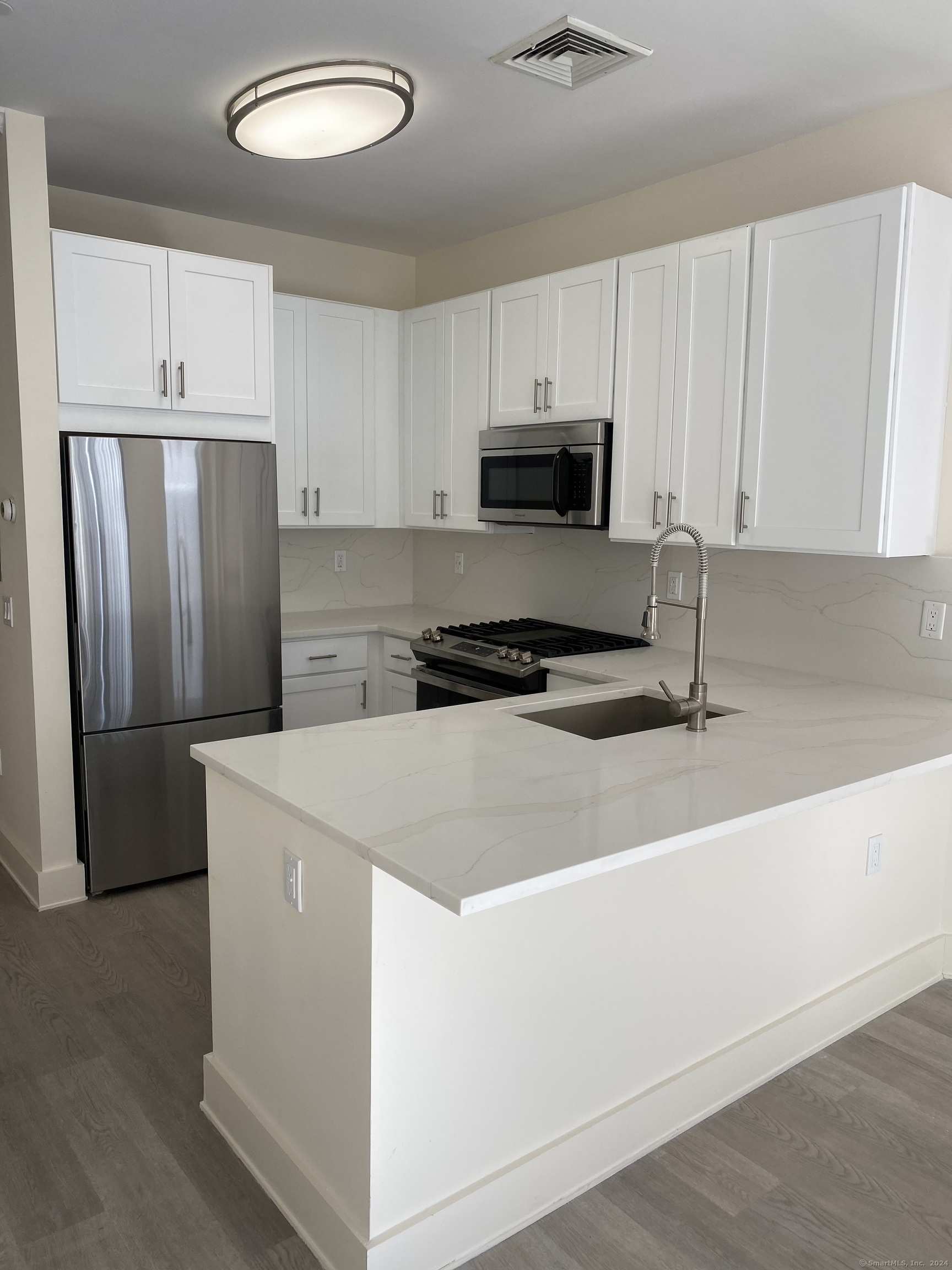 75 Prospect Street Stamford, CT 06901 - Photo 9 of 15 a kitchen with a refrigerator stove and white cabinets