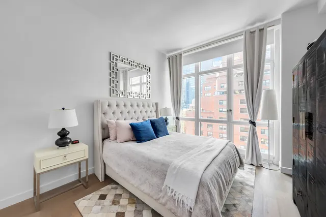 a bedroom with a bed and a large window