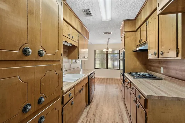 a kitchen with a sink stove and cabinets