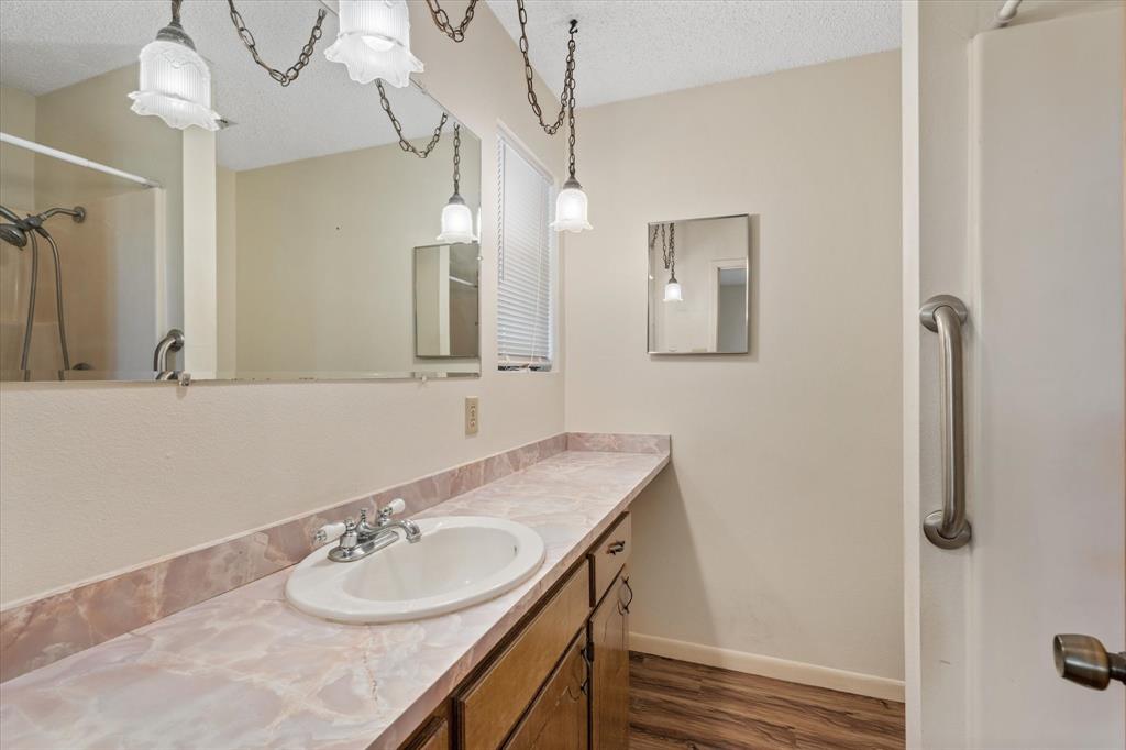 2711 Tin Top Road Weatherford, TX 76087 - Photo 18 of 22 a bathroom with a granite countertop sink and a mirror