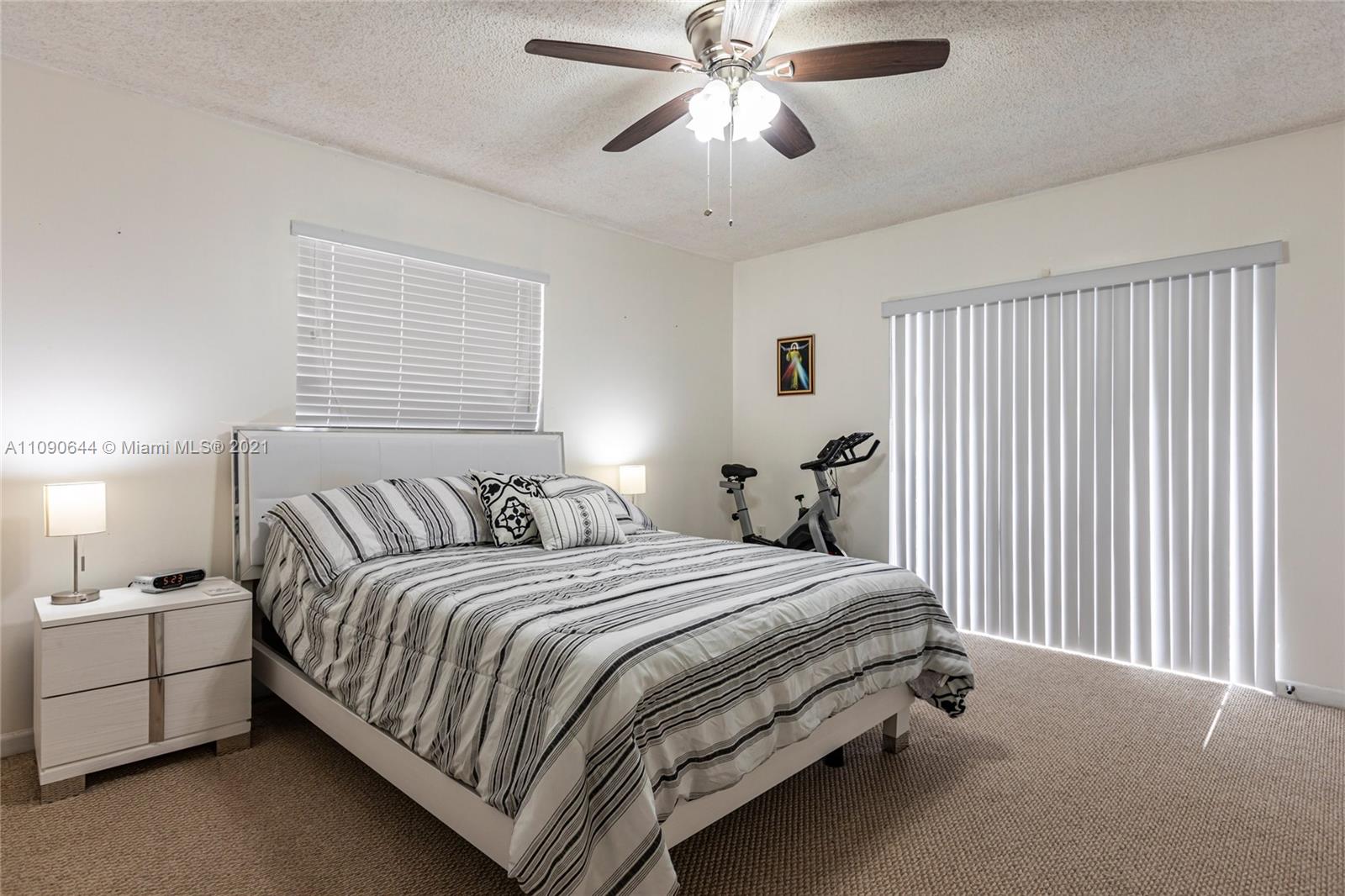 1925 Southwest 118th Court, Unit 138 Miami, FL 33175 - Photo 11 of 15 a bedroom with a bed and a chandelier