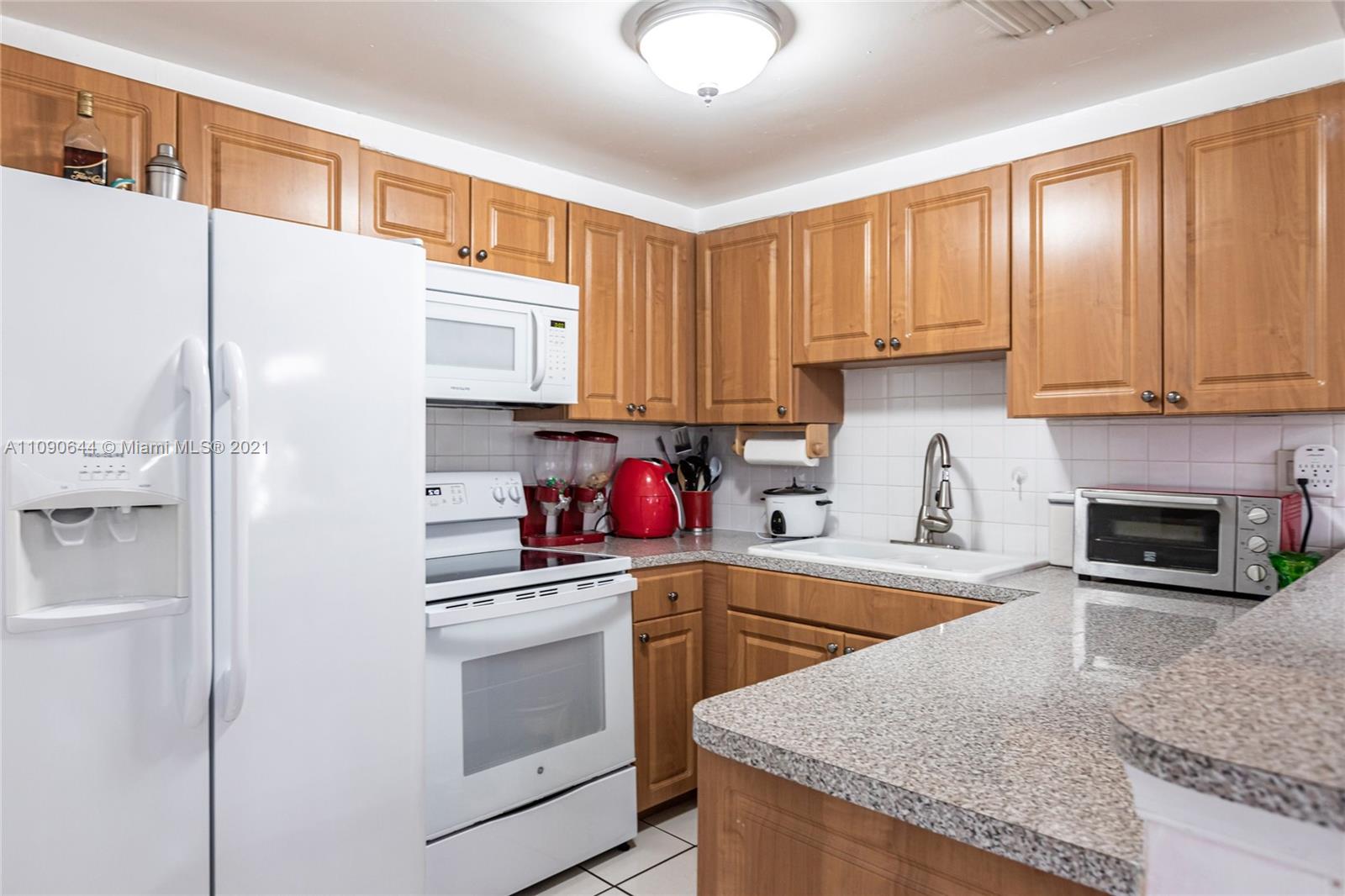 1925 Southwest 118th Court, Unit 138 Miami, FL 33175 - Photo 5 of 15 a kitchen with granite countertop a refrigerator stove and sink