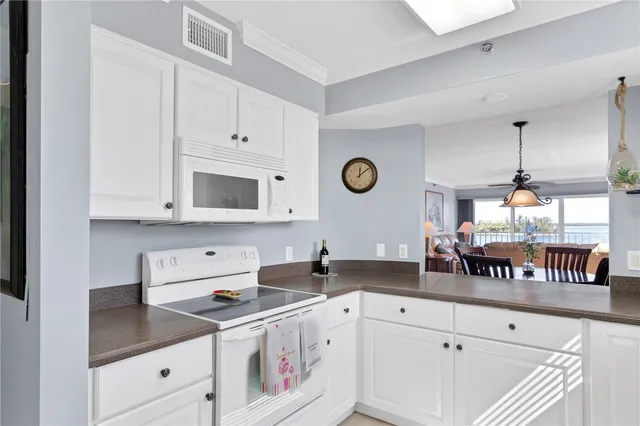 a kitchen with granite countertop a sink a stove a refrigerator a counter space and cabinets