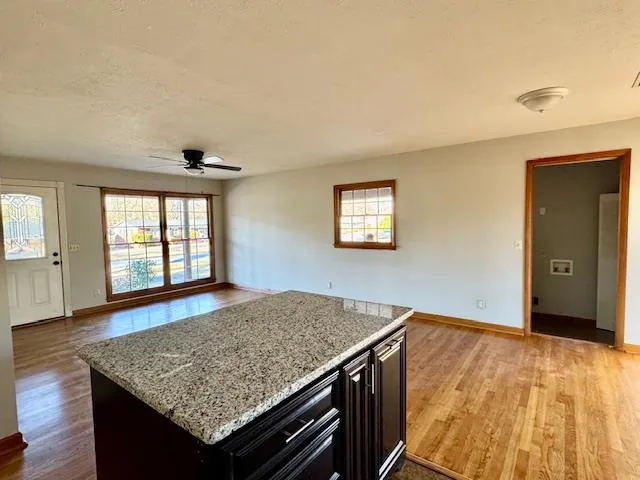 a view of kitchen island with hallway and wooden floor