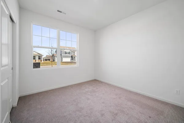 an empty room with windows and cabinet