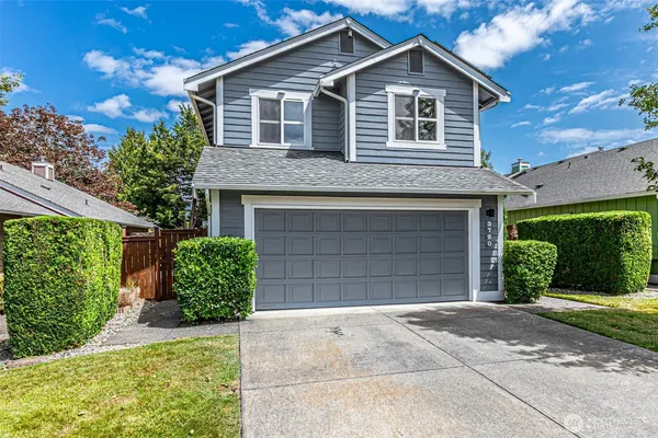 a front view of a house with a yard and garage