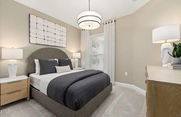 a bedroom with a bed and a lamp on dresser