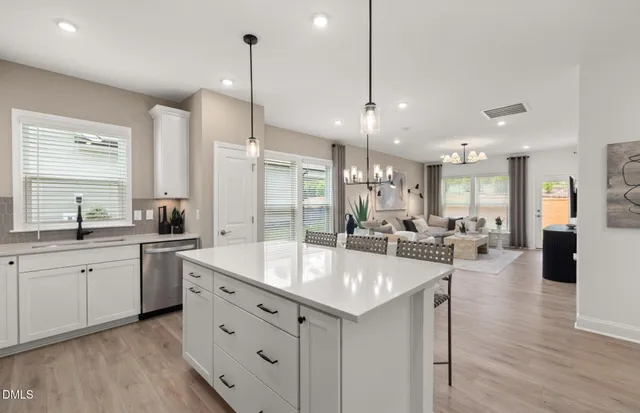 a large kitchen with kitchen island a sink table and chairs