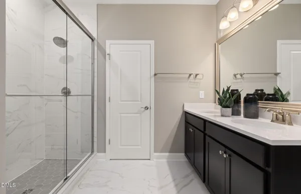 a bathroom with a double vanity sink a mirror and shower