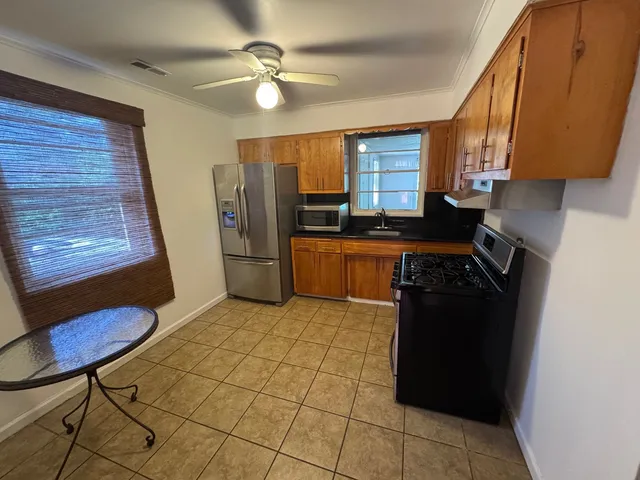 a kitchen with stainless steel appliances granite countertop a refrigerator and a sink