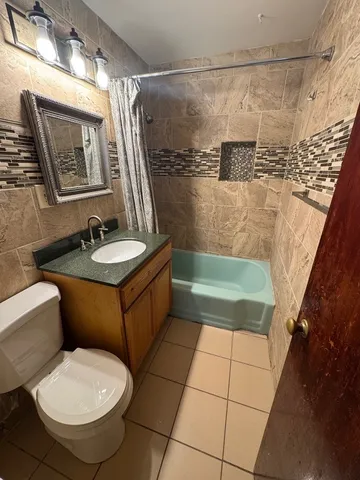 a bathroom with a sink a toilet a mirror a vanity and bathtub