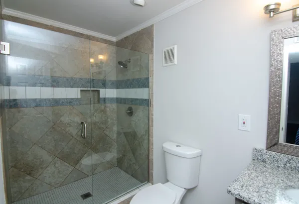 a bathroom with a granite countertop sink a toilet and shower