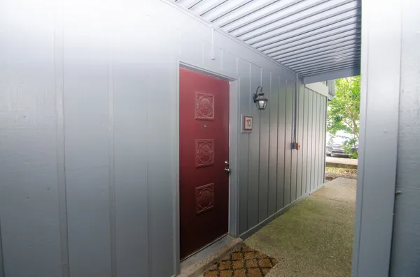 a front view of a house with a yard and potted plants