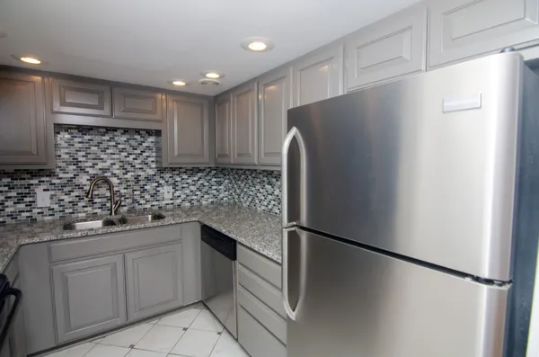 a kitchen with stainless steel appliances granite countertop a refrigerator and a sink