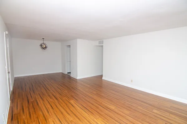a view of an empty room with wooden floor