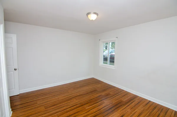 a view of a room with wooden floor and white walls