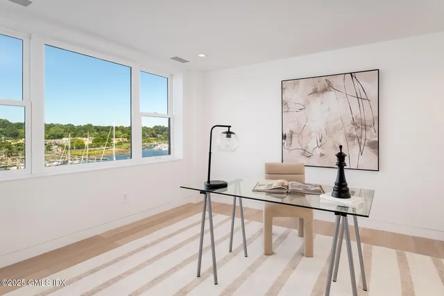 a view of a workspace room with furniture and a window