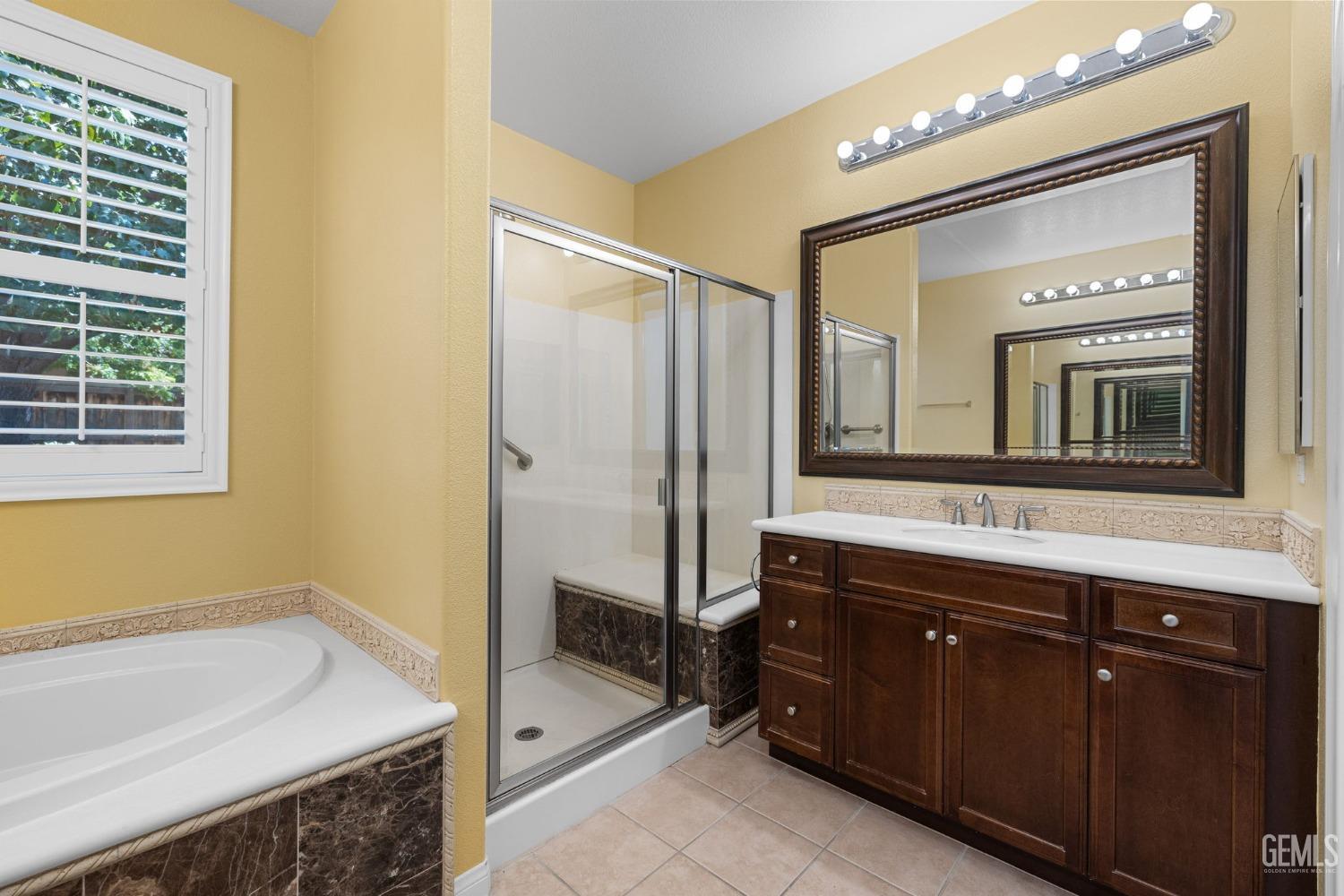 Undisclosed Address Bakersfield, CA 93306 - Photo 17 of 36 a spacious bathroom with a tub sink and mirror