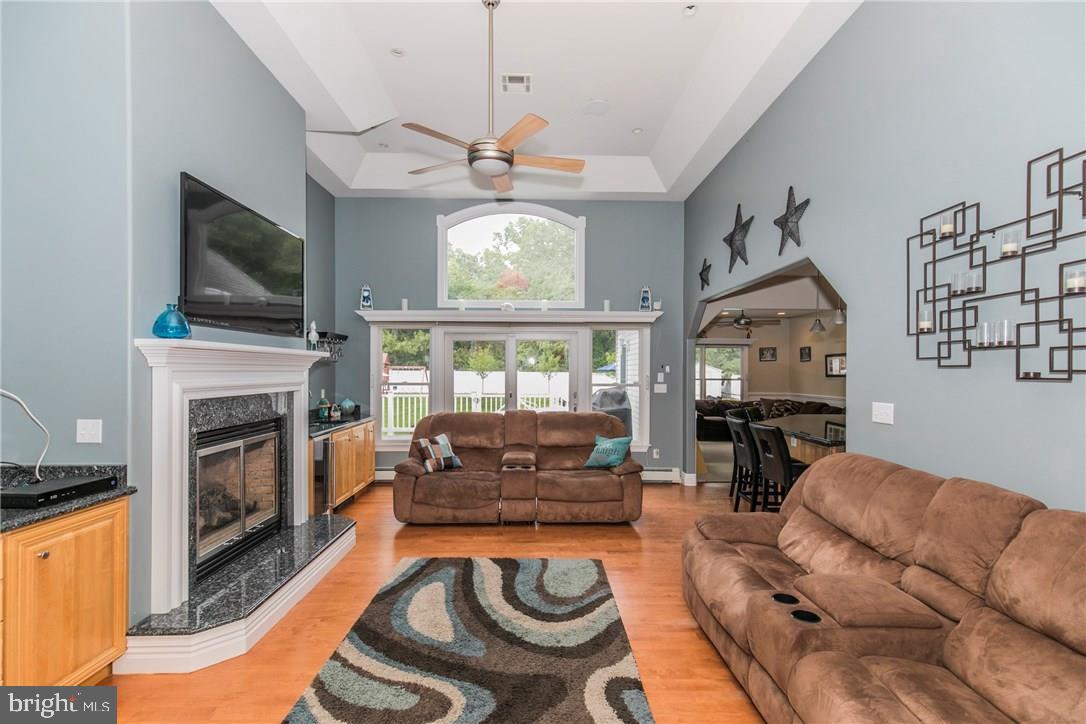 39 Harbor Inn Road Bayville, NJ 08721 - Photo 12 of 27 a living room with furniture a flat screen tv and a fireplace