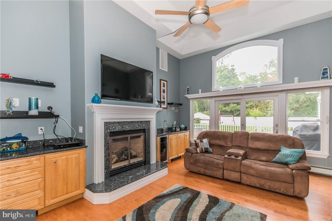 39 Harbor Inn Road Bayville, NJ 08721 - Photo 13 of 27 a living room with furniture a flat screen tv and a fireplace