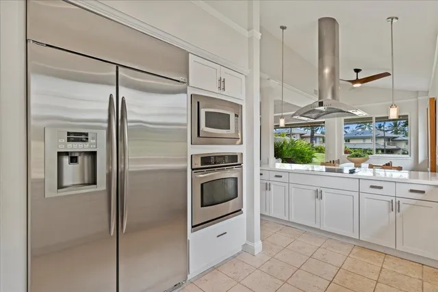 a kitchen with stainless steel appliances granite countertop a refrigerator and a stove top oven