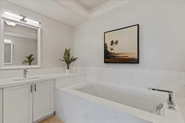 a white bath tub sitting next to a bathroom sink