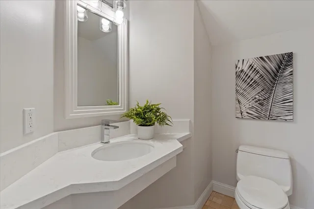 a bathroom with a sink a toilet and mirror