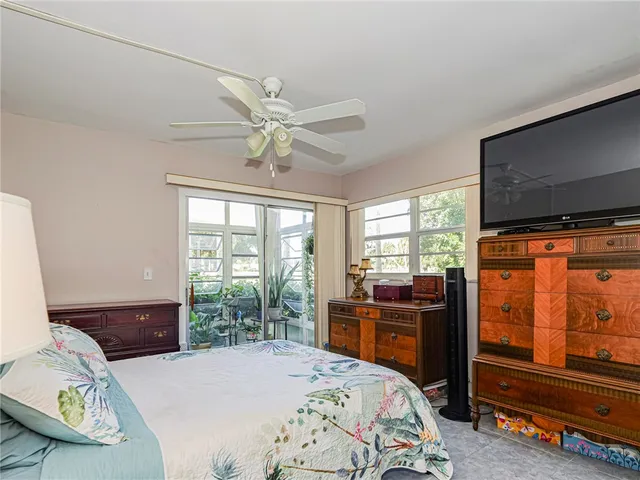a bedroom with a bed and large windows