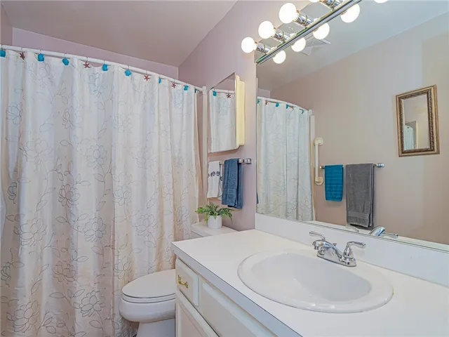 a bathroom with a sink vanity mirror and toilet