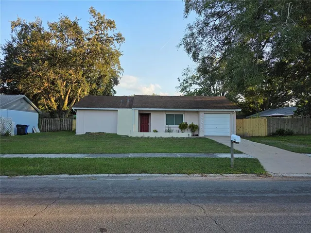 a front view of a house with a garden and trees