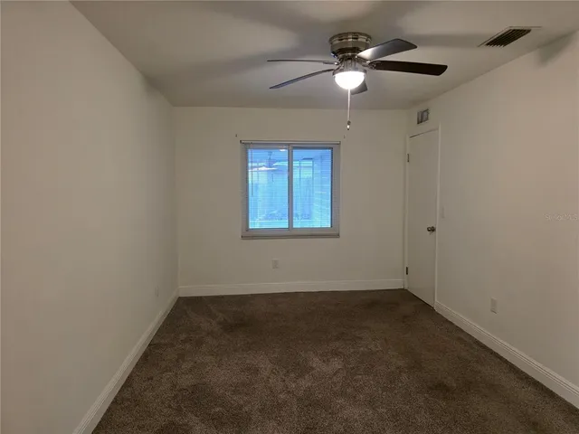 a view of a room with a ceiling fan and a window
