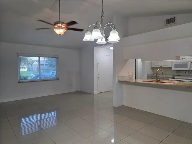 a view of kitchen with granite countertop cabinets and chandelier