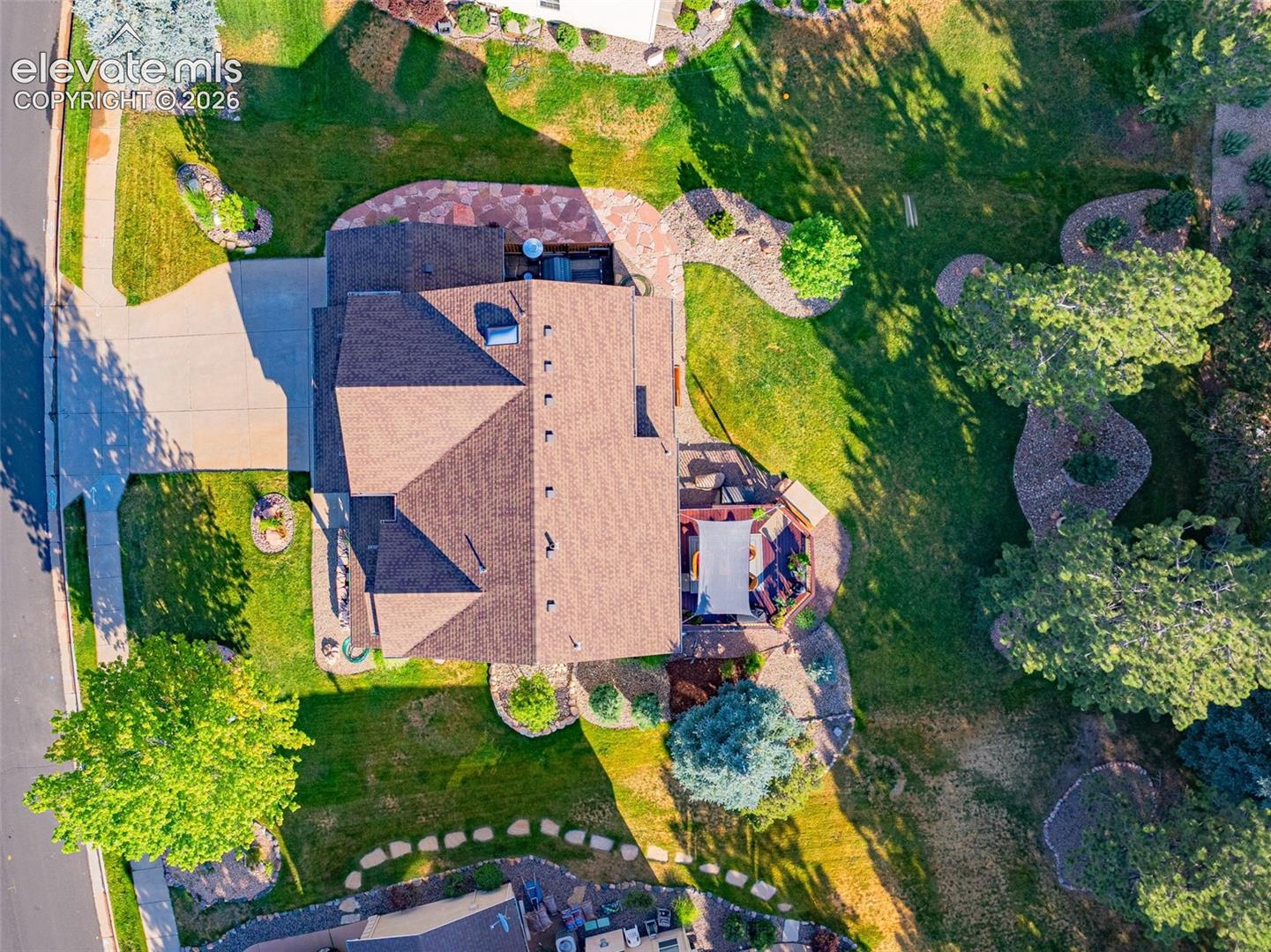 7985 Orchard Path Road Colorado Springs, CO 80919 - Photo 3 of 50 Expansive lot with a pitched roofline, concrete driveway, and a backyard deck