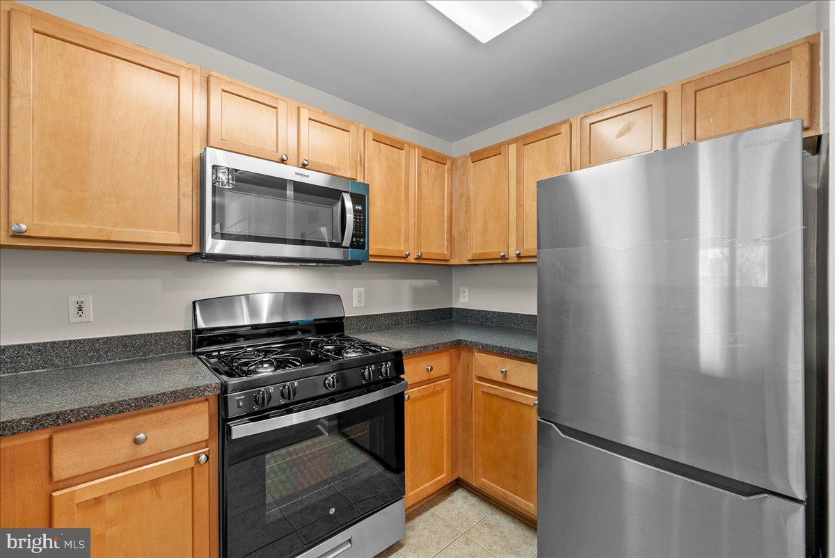 12000 Market Street, Unit 469 Reston, VA 20190 - Photo 11 of 41 a kitchen with stainless steel appliances granite countertop a refrigerator stove and microwave
