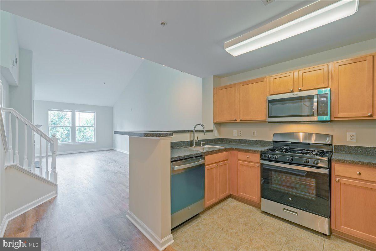12000 Market Street, Unit 469 Reston, VA 20190 - Photo 12 of 41 a kitchen with stainless steel appliances granite countertop a stove a sink and a microwave