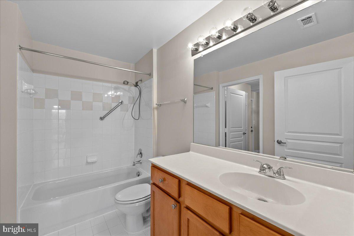 12000 Market Street, Unit 469 Reston, VA 20190 - Photo 15 of 41 a bathroom with a granite countertop sink a toilet a mirror and shower