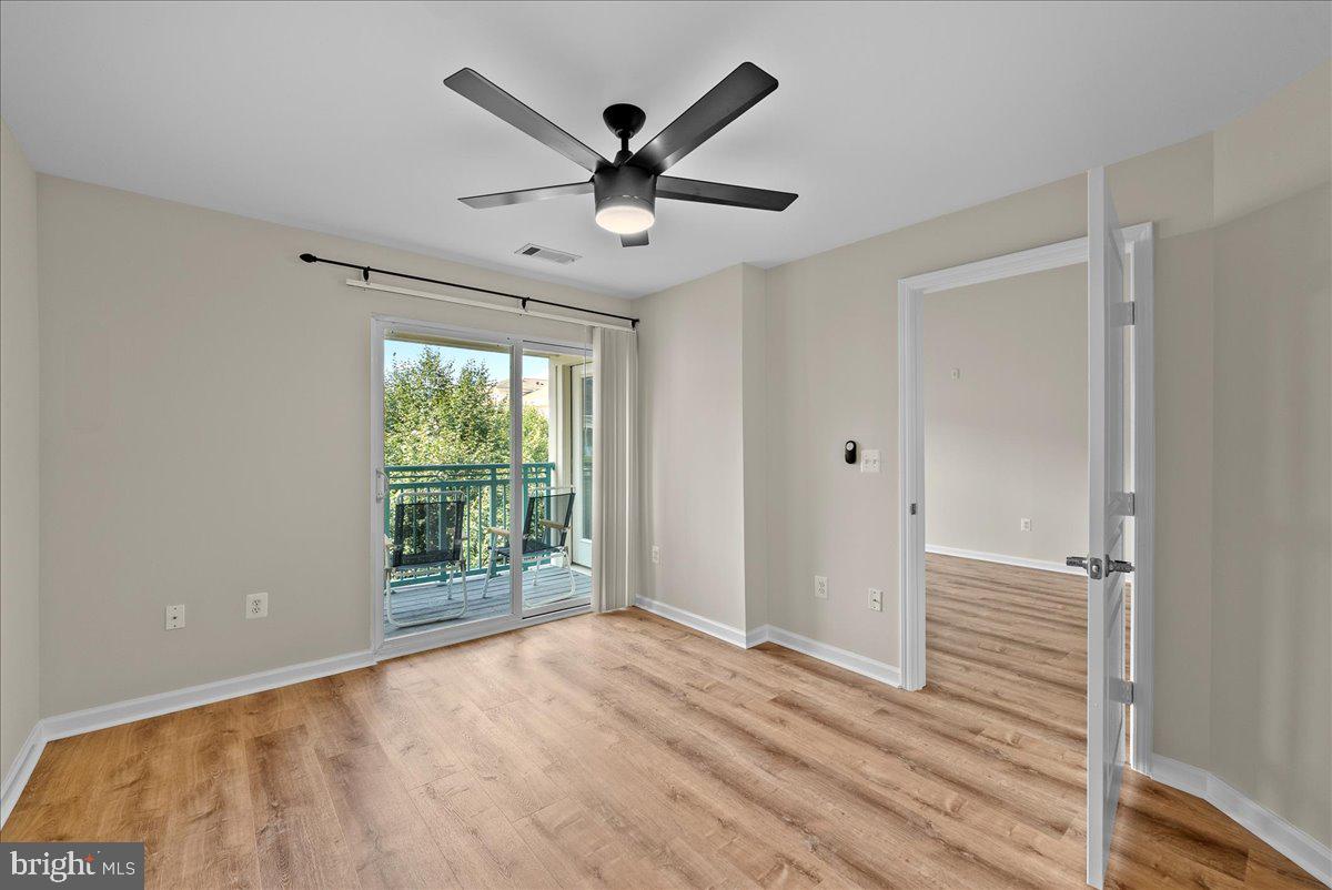 12000 Market Street, Unit 469 Reston, VA 20190 - Photo 6 of 41 a view of an empty room with wooden floor and a window